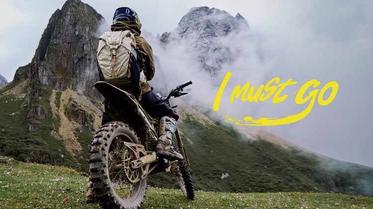 Surron electric dirt bike rider overlooking a mountain trail